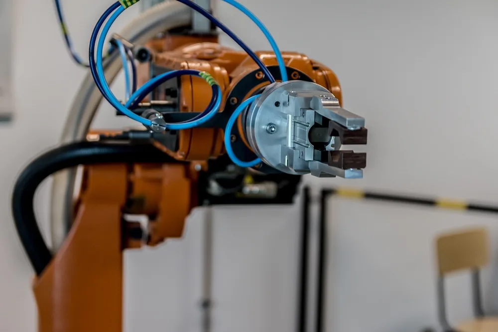 An orange industrial robot arm fitted with a gripper