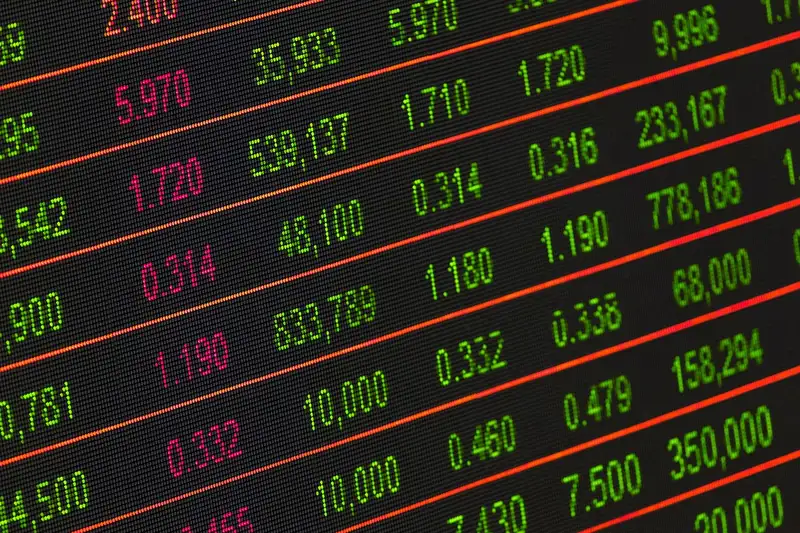 Close-up of a market data display showing rows of green and red figures
