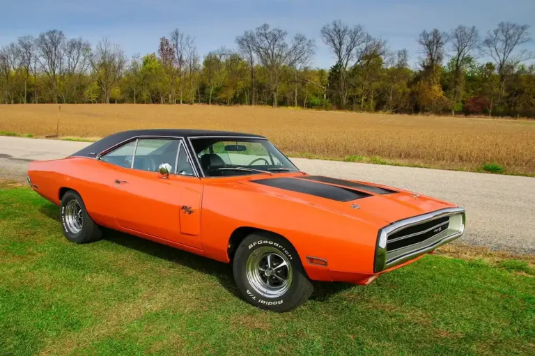 Orange 1970 Dodge Charger R/T parked beside a farm field