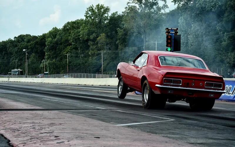 Muscle car launching off the line at a drag strip Muscle car launching off the line at a drag strip