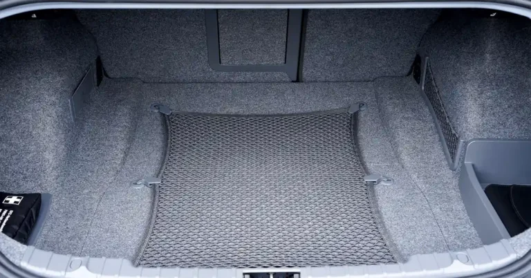 Empty car trunk with a cargo net stretched across the floor and tie-down anchors