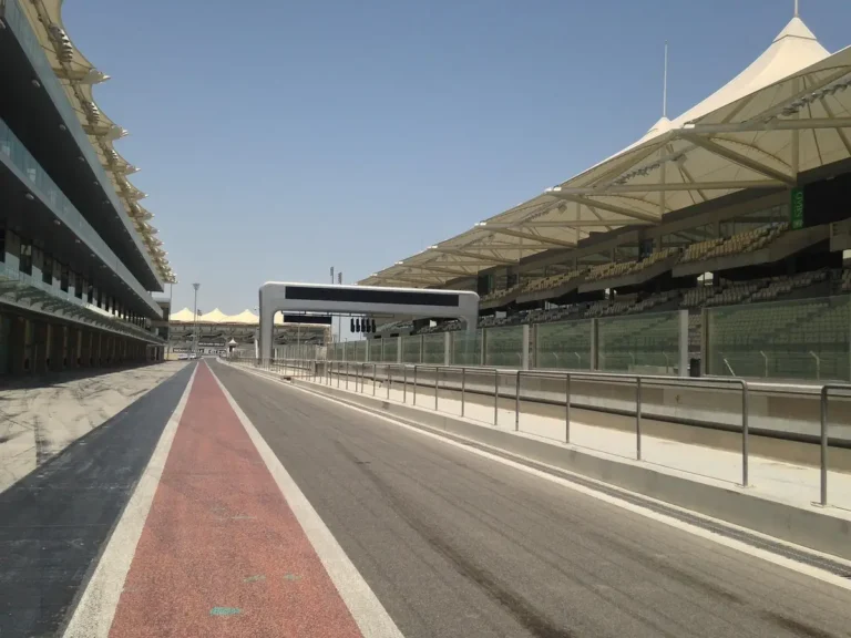 Empty pit lane and covered grandstand at a Grand Prix circuit