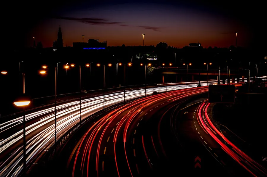 Long-exposure photo of highway traffic at dusk with streaks of headlight and taillight