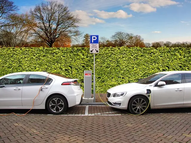 Two electric cars charging at a roadside charging post