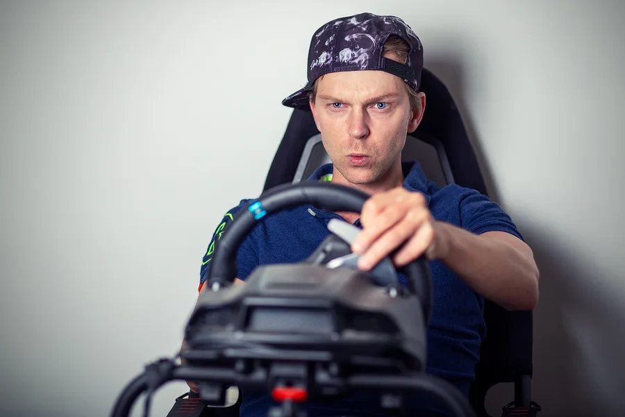 Driver gripping a racing simulator wheel, the kind of practice Jackson Storm is shown using in Cars 3