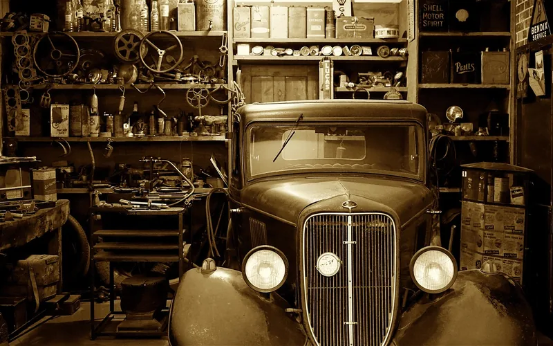 mechanic sanding and repairing a dented car door panel in an auto body workshop