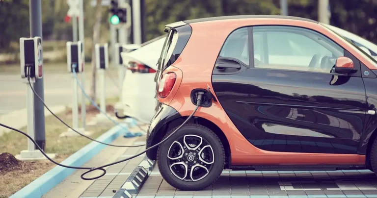 Small electric car plugged in at a public charging station