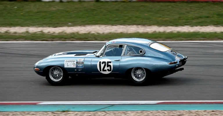 Vintage blue sports coupe with a race number driving on a race circuit