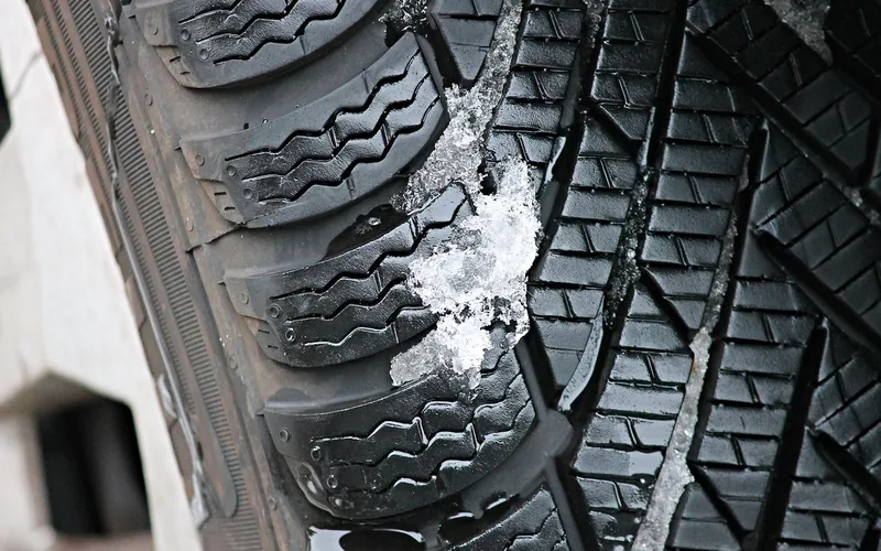 Close-up of a winter tire tread with deep grooves for grip in snow Close-up of a winter tire tread with deep grooves for grip in snow
