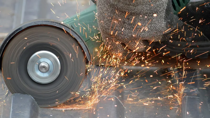 Angle grinder throwing sparks while cutting metal Angle grinder throwing sparks while cutting metal