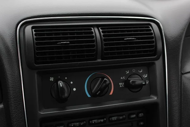 Car dashboard climate control panel with air conditioning knobs and vents