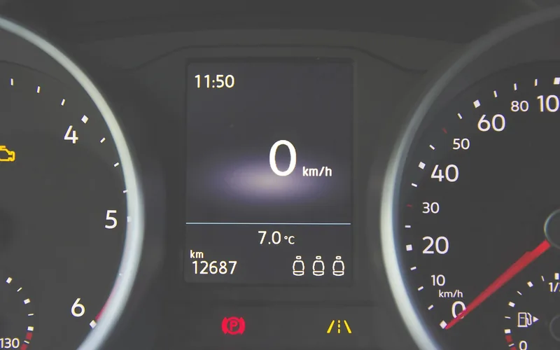 Car instrument cluster with an amber engine-shaped warning symbol lit