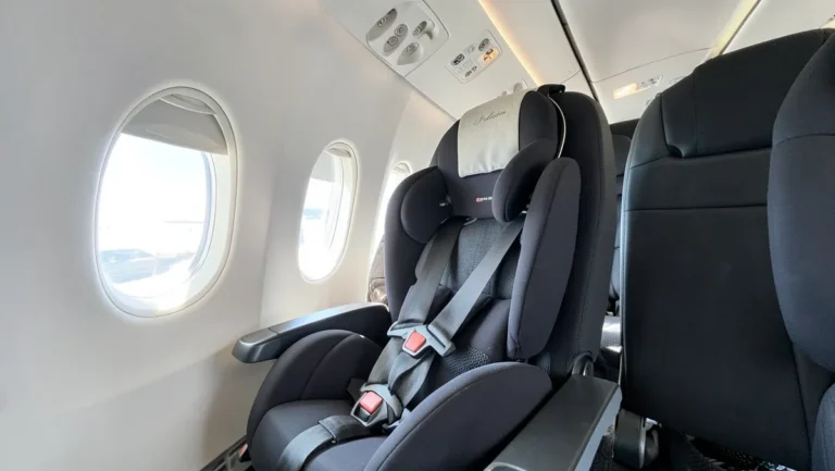 FAA-approved child car seat installed in an airplane window seat using the seatbelt