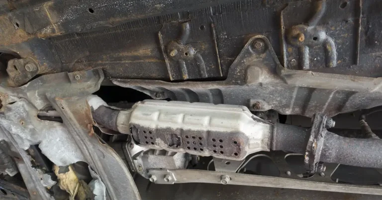Underside of an older car showing exhaust, floor pan and mounting brackets