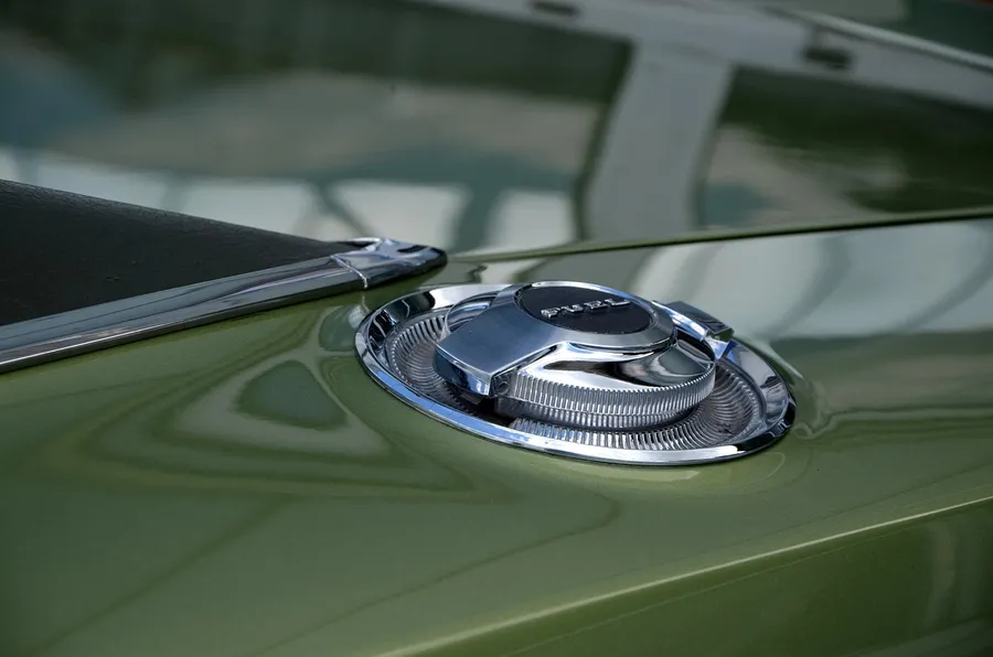 Chrome fuel filler cap on the body of a green classic car
