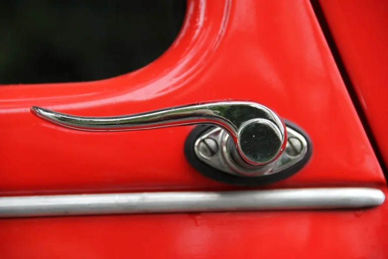 Chrome lever door handle on a red car door