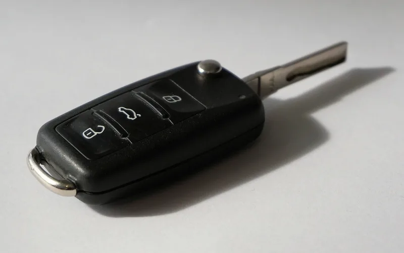 Flip key fob lying on a grey surface with the seam between the case halves visible