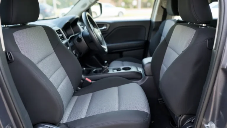 Front bucket seats of a full-size SUV fitted with two-tone gray and black aftermarket seat covers