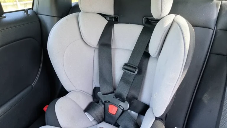 Gray convertible child car seat with five-point harness buckled in a vehicle back seat