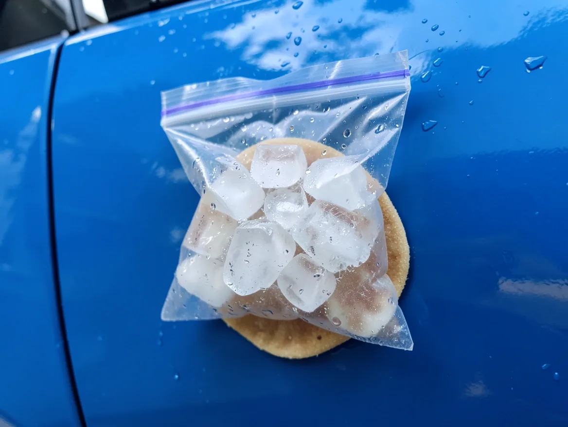 bag of ice cubes hardening gum on a car door panel