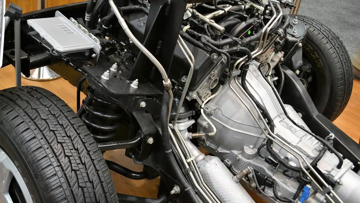 Mechanic inspecting an engine bay to diagnose the cause of an emissions test failure