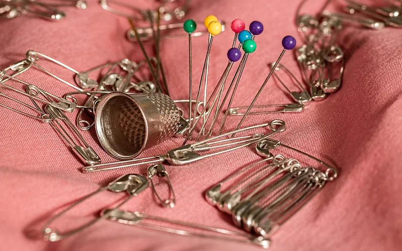 Curved upholstery needle and heavy-duty thread used to hand-sew a fabric seat tear
