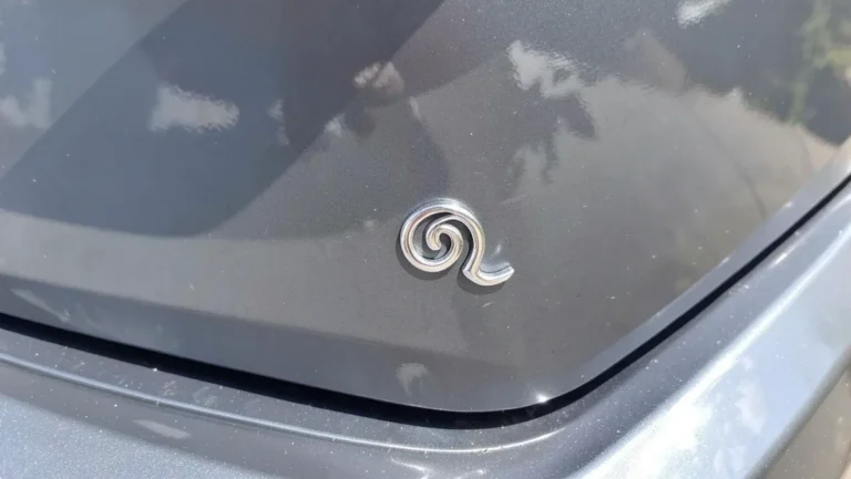 Chrome silver swirl decal applied to the corner of a car rear window trunk panel