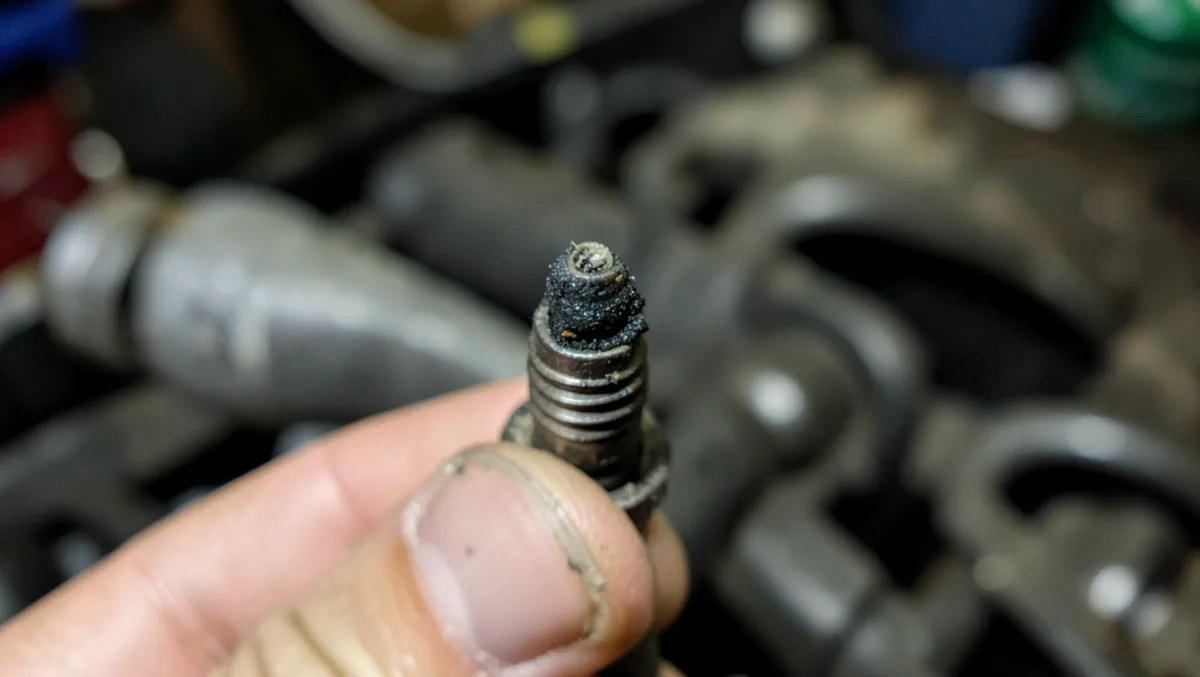 A black, sooty spark plug tip is a classic sign of a rich-running engine