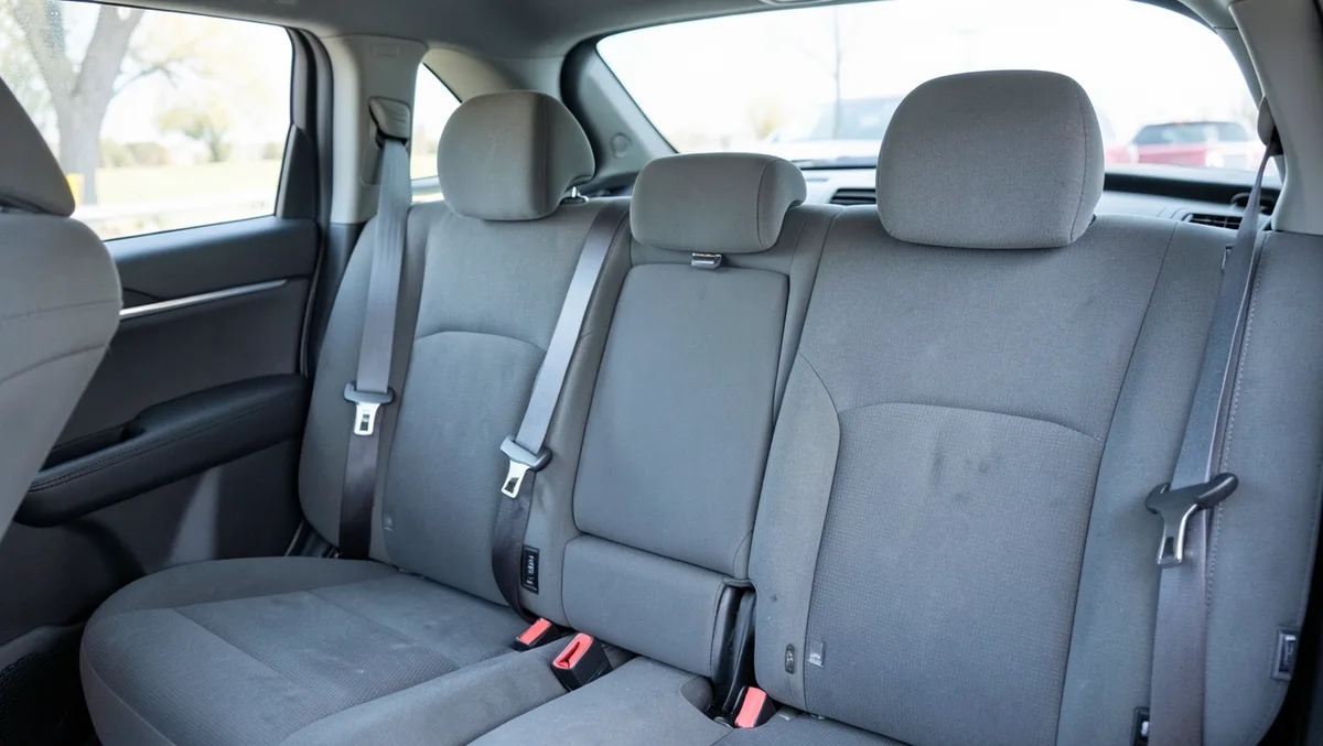 Second-row bench seat inside a full-size SUV with gray seat covers and integrated headrests