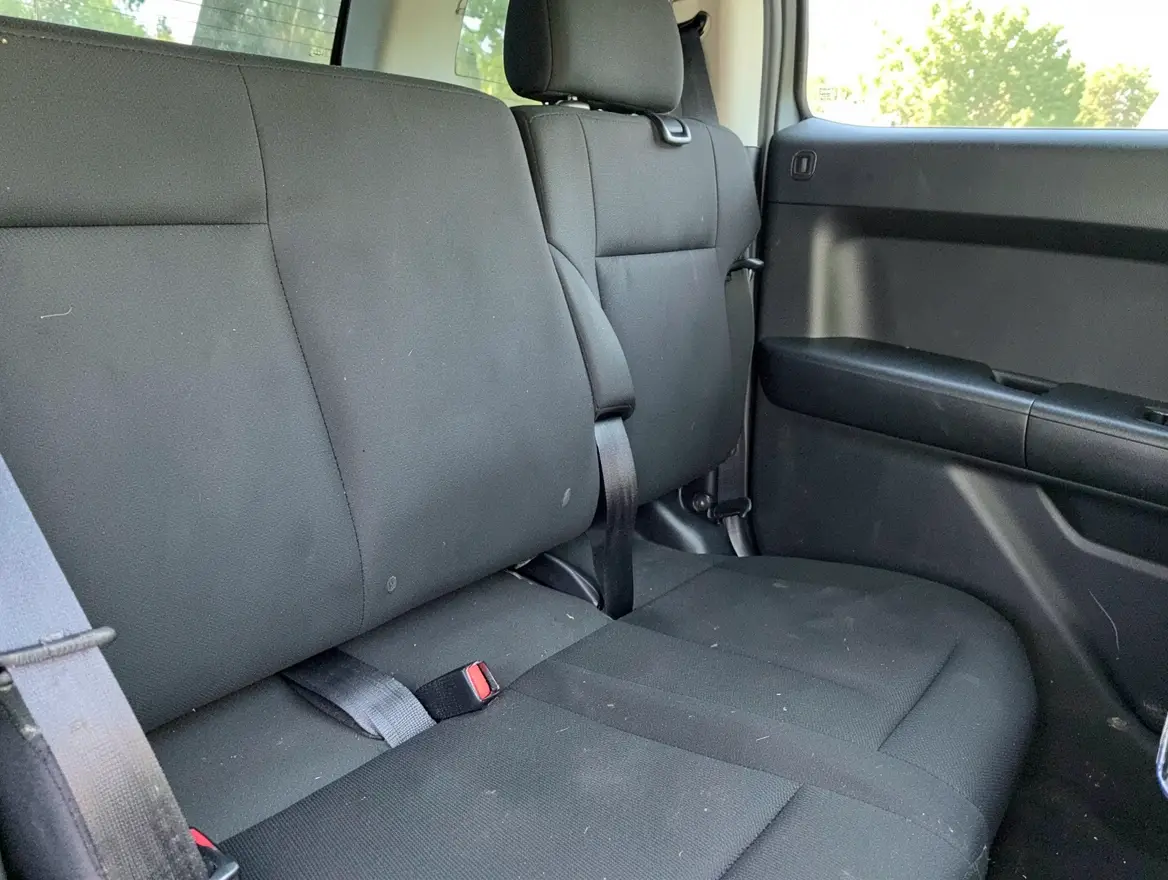 Toyota Tacoma Access Cab rear jump seats folded up with seatbelt buckles visible