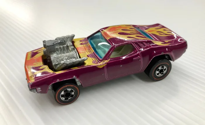 Vintage Redline-era Hot Wheels muscle car with flame paint and an exposed engine