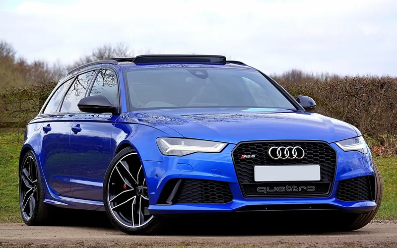 Blue Audi RS 6 Avant station wagon with quattro badge parked on a dirt track Blue Audi RS 6 Avant station wagon with quattro badge parked on a dirt track