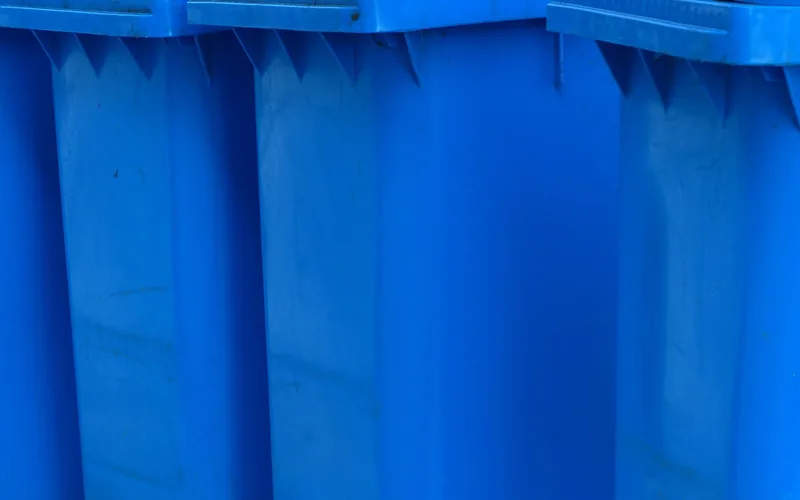 Row of blue wheeled recycling bins