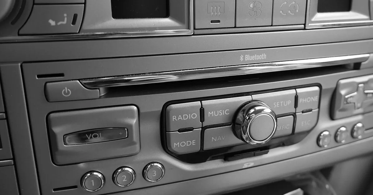 Car dashboard audio unit with a CD slot, volume control and mode buttons