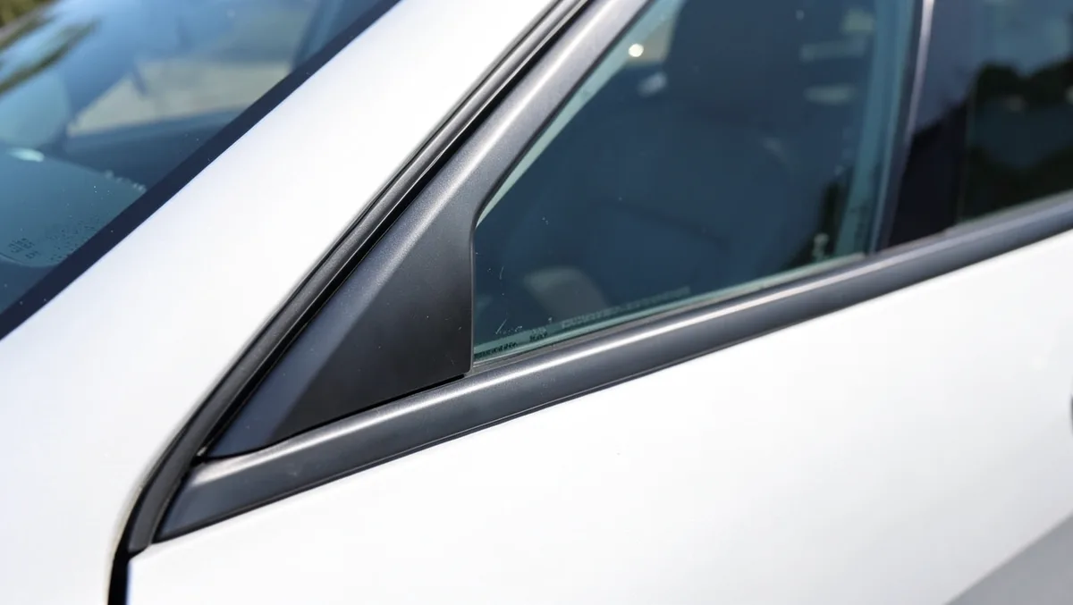 Close-up of a car side window and rubber weatherstripping seal along the door frame