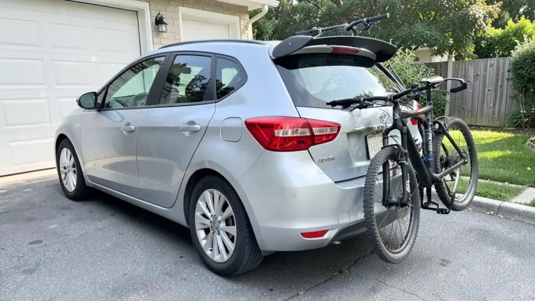 Silver hatchback with a visible rear spoiler and a trunk-mounted bike rack carrying two bikes