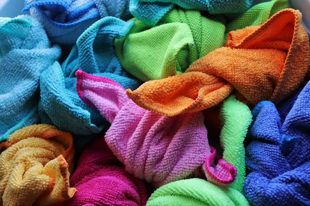 A pile of colorful microfiber cloths in blue, green, orange, pink and yellow