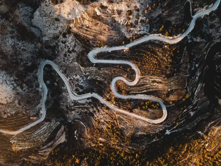 Aerial view of a winding mountain road with several hairpin bends