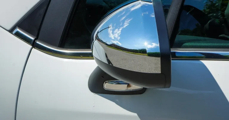 Chrome side mirror on a white parked car