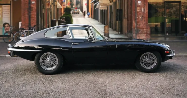 Black Jaguar E-Type coupe parked on a city street