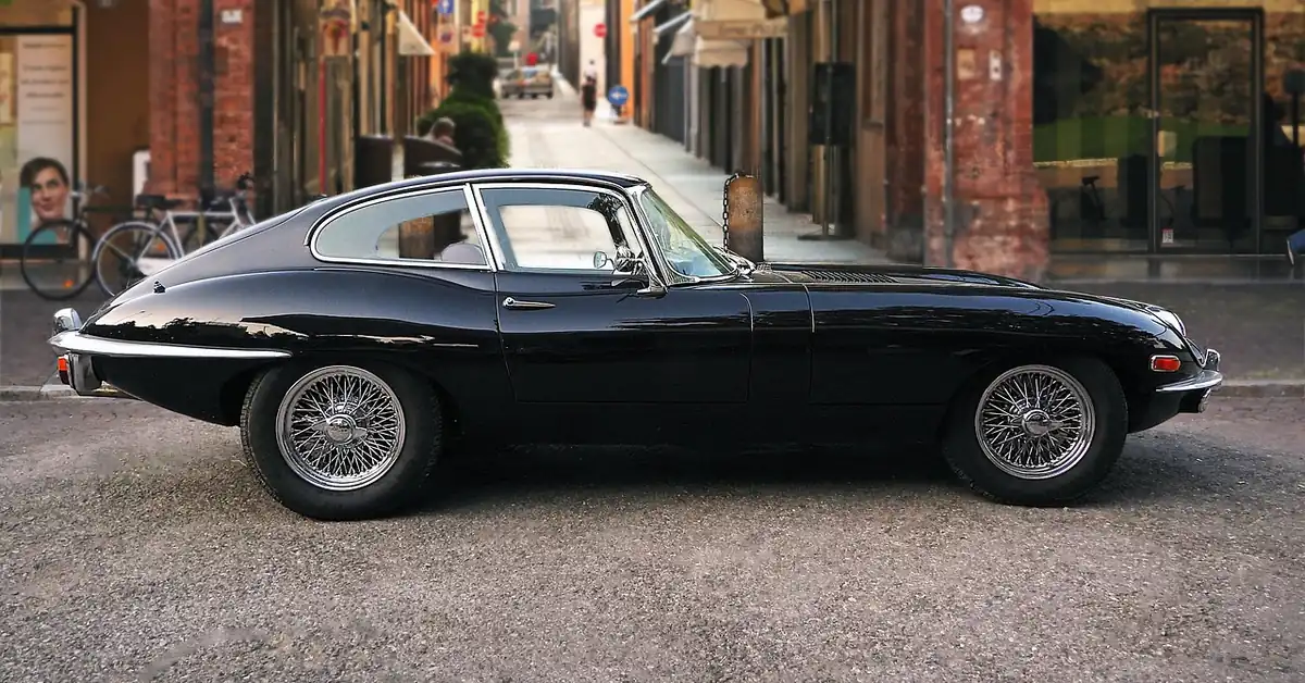 Black Jaguar E-Type coupe parked on a city street