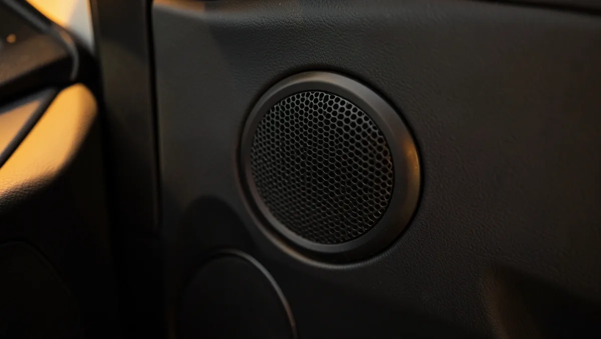 Aftermarket car door speaker grille installed in a vehicle door panel