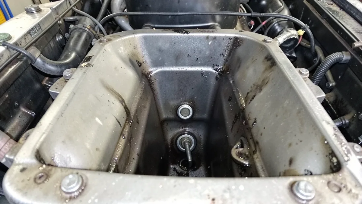 Knock sensor bolted into the engine valley between two cylinder banks of a V8 with the intake manifold removed