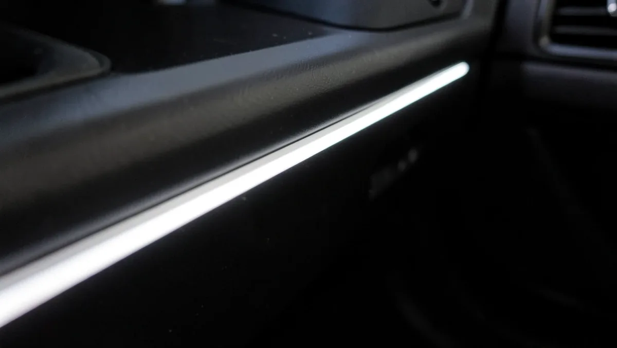 White LED strip light glowing along a car door sill trim panel