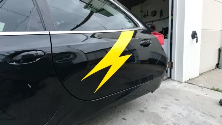 Yellow lightning bolt vinyl decal applied to the rear door and quarter panel of a black car