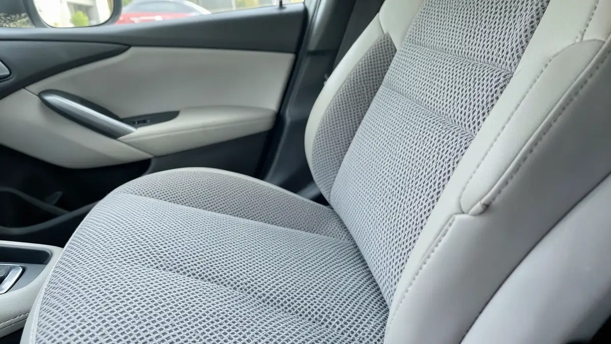 Gray breathable mesh seat cover installed on a car front seat showing the honeycomb weave texture