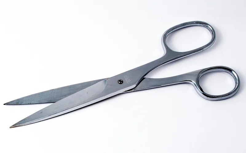 Metal household scissors open on a white background