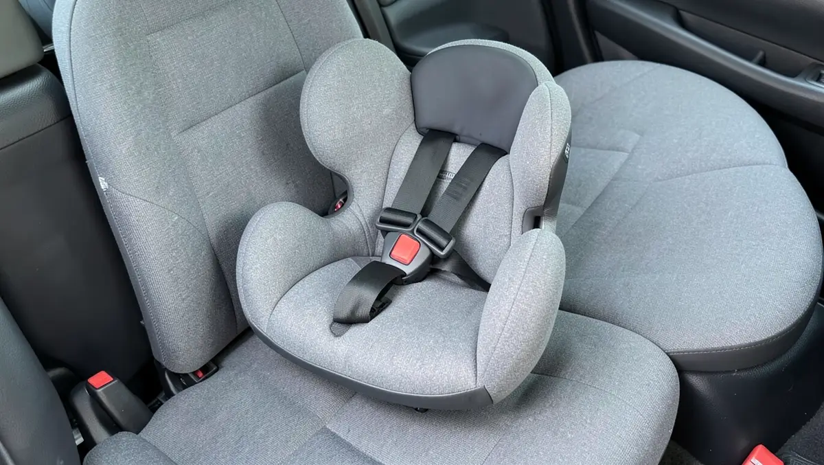 Clean convertible child car seat with a five-point harness installed in the back seat of a car