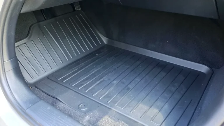 Black heavy-duty rubber trim-to-fit floor mat installed in a car footwell