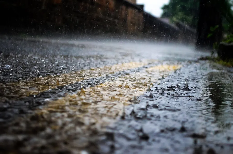 Raindrops splashing on a wet road surface